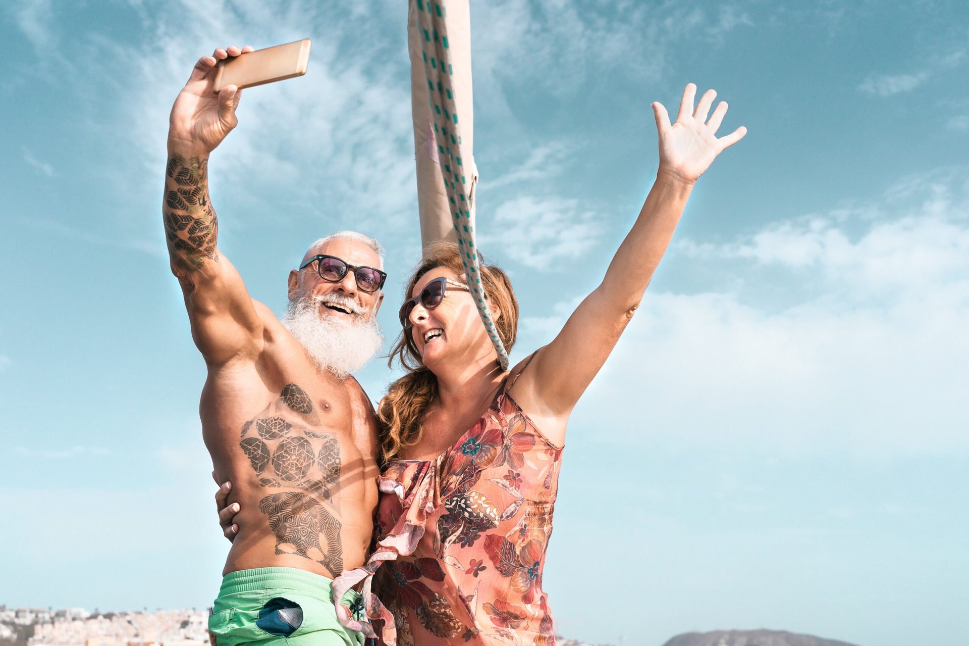 Senior couple taking selfie with mobile smartphone on sailboat